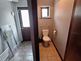 A bathroom featuring a toilet and sink at Lilly's Bungalow in Timoleague