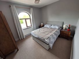A bedroom with a bed and bedside tables at Lilly's Bungalow in Timoleague