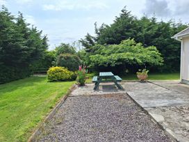 A garden with a table and bench at Lilly's Bungalow in Timoleague