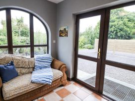 A conservatory with a sofa and window at Lilly's Bungalow in Clonakilty, County Cork