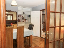 A dining room with a table and bookshelf at Lilly's Bungalow in Clonakilty, County Cork