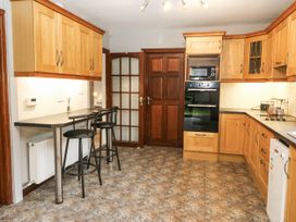 A kitchen with wooden cabinets and a countertop at Lilly's Bungalow in Clonakilty, County Cork