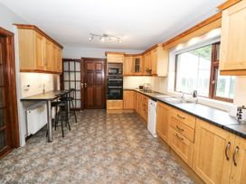 A kitchen with wooden cabinets and appliances at Lilly's Bungalow in Clonakilty, County Cork