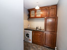 A kitchen with cupboards and a washing machine at Lilly's Bungalow, Clonakilty, County Cork