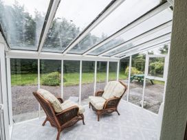 A conservatory with two chairs and a table at Lilly's Bungalow in Clonakilty, County Cork