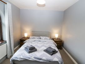 A bedroom with a bed, nightstand and lamp at Lilly's Bungalow in Clonakilty, County Cork