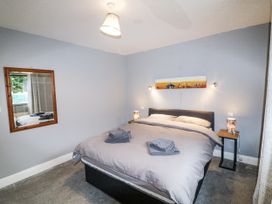 A bedroom with a bed and a mirror at Lilly's Bungalow Clonakilty County Cork