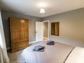 A bedroom with a wooden wardrobe and a bed with towels at Lilly's Bungalow in Clonakilty, County Cork