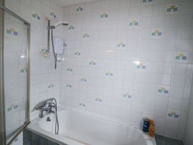 A bathroom with a shower above the bathtub at Lilly's Bungalow in Clonakilty, County Cork