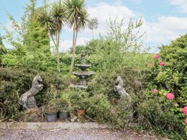 A garden with a fountain and stone statues at Lilly's Bungalow Clonakilty County Cork