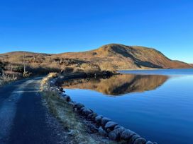 A road beside a lake with a mountain in the background at Carrowreagh, Aclare, County Sligo
