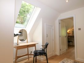 A bedroom with a desk and a chair at Lakeside Lodge in Witherenden Hill near Burwash