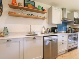 A kitchen with cabinets, sink, and appliances at Lakeside Lodge in Witherenden Hill near Burwash