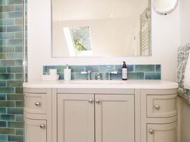 A bathroom with a sink and mirror at Lakeside Lodge in Witherenden Hill near Burwash