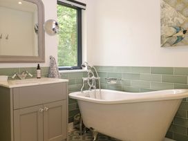 A bathroom with a bathtub and sink at Lakeside Lodge near Witherenden Hill Burwash