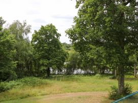 A view of trees and water at Lakeside Lodge in Witherenden Hill near Burwash
