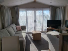 A living room with a sofa and television at The Maples, no. 56 St. Austell