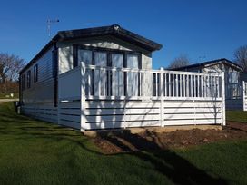 A mobile home with a deck and fence at The Maples, no. 56 St. Austell