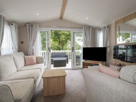 A living room with a sliding door leading to a deck at The Maples, no. 56 Hewas Water near Polgooth