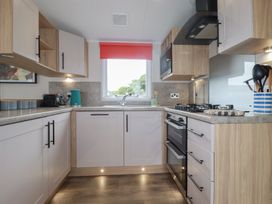 A kitchen with cabinets and appliances at The Maples, no. 56 Hewas Water near Polgooth