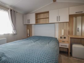 A bedroom with a bed and wardrobe at The Maples, no. 56 Hewas Water near Polgooth