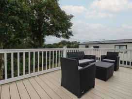 An outdoor seating area with chairs and a table at The Maples, no. 56 Hewas Water near Polgooth