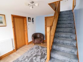 A hallway with a staircase and a chair at Pendre Barn in Star near Cenarth