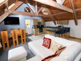 A living room with a sofa and dining area at Pendre Barn Star near Cenarth