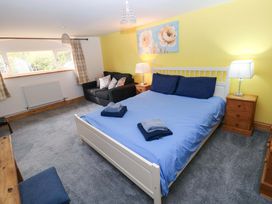 A bedroom with a bed and a sofa at Pendre Barn Star near Cenarth