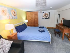 A bedroom with a bed and wardrobe at Pendre Barn Star near Cenarth