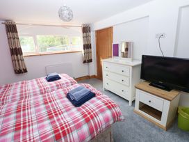 A bedroom with two beds and a television at Pendre Barn Star near Cenarth