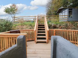 A wooden deck area with stairs leading to a fenced area at Pendre Barn Star near Cenarth