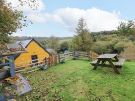 A garden with a picnic table and planters at Pendre Barn Star near Cenarth