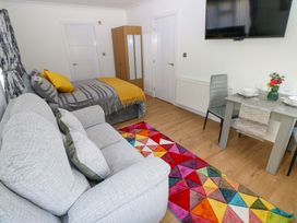 A bedroom with a sofa and a dining table at Pinecroft Annex Stepaside near Saundersfoot