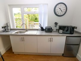 A kitchen with a sink, toaster, microwave and kettle at Pinecroft Annex Stepaside near Saundersfoot