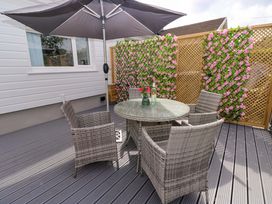 An outdoor seating area with a table and chairs at Pinecroft Annex Stepaside near Saundersfoot