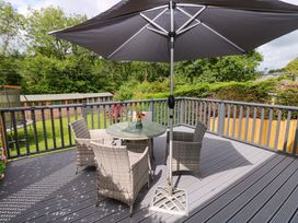 An outdoor patio with a table and chairs at Pinecroft Annex Stepaside near Saundersfoot
