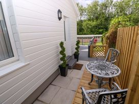 An outdoor area with a table and chairs at Pinecroft Annex Stepaside near Saundersfoot
