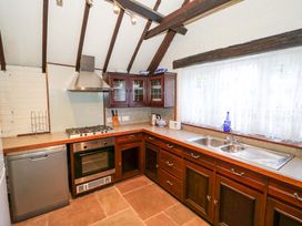 A kitchen with appliances and cabinets at Fern Cottage