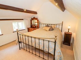 A bedroom with a bed and dresser at Fern Cottage