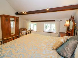 A bedroom with a bed and wardrobe at Fern Cottage