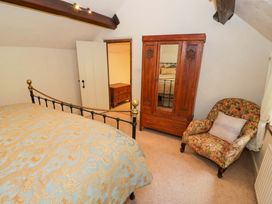 A bedroom with a bed and wardrobe at Fern Cottage in 