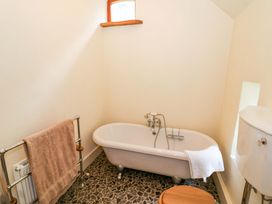 A bathroom with a bathtub and towel rack at Fern Cottage in 