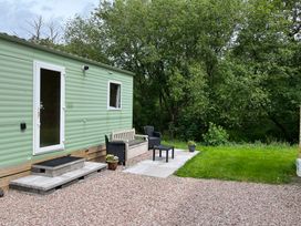 An outdoor space with a mobile home and seating area at Sylvan in Builth Wells