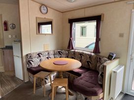 A dining area with a round table and seating at Sylvan in Builth Wells