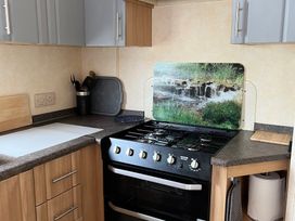 A kitchen with a stove and utensils at Sylvan in Builth Wells
