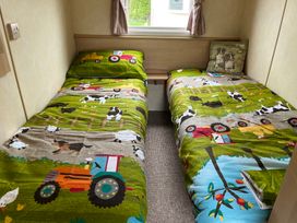 A bedroom with two single beds and a window at Sylvan in Builth Wells