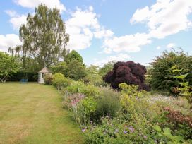 A garden with flowers and a shed at Uplands House Ledbury