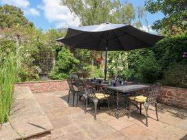 A garden with a dining table and chairs at Uplands House in Ledbury
