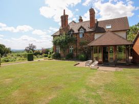 A house with a garden and seating area at Uplands House in Ledbury